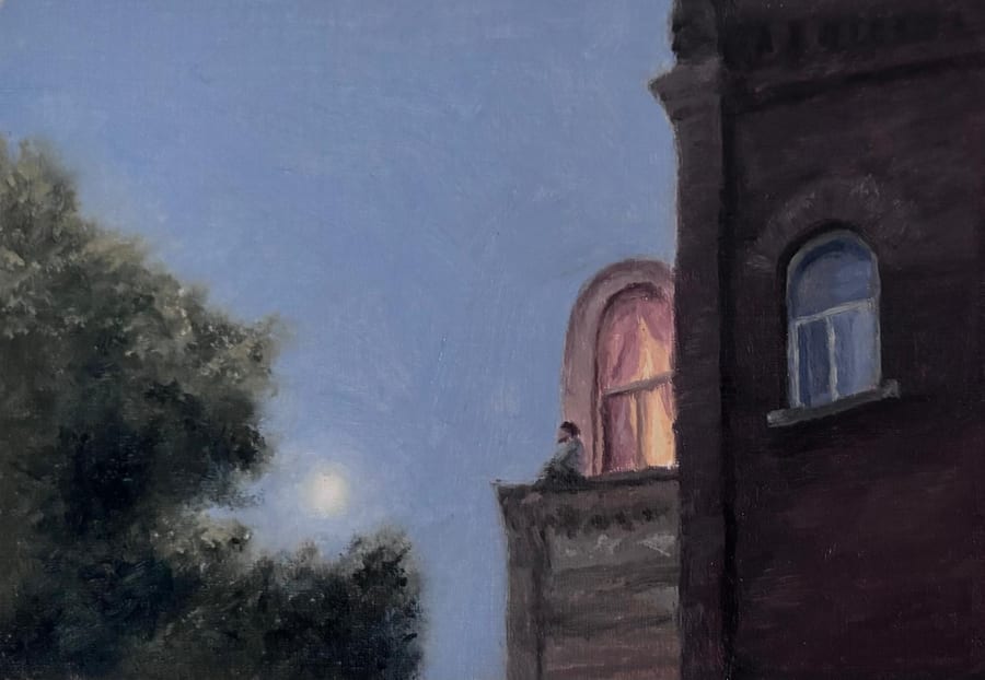 A deep blue evening sky with a pale moon behind a dark leafy tree. On a rooftop terrace beside a brick building, a small figure sits in front of a warmly glowing arched window.